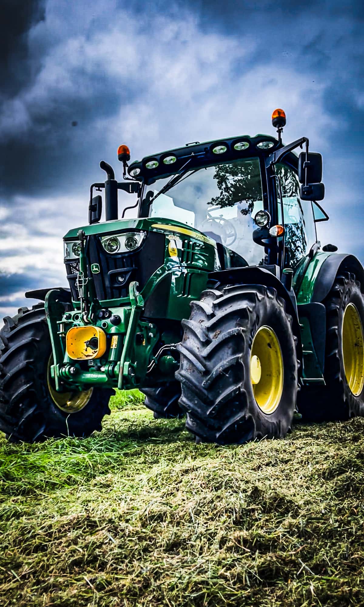 Agricultural contractor’s tractor and implements parked in a farm yard